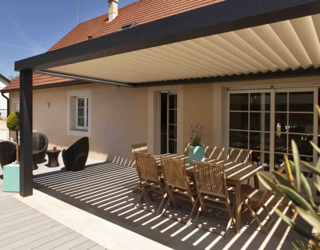 The brown aluminum pergola shades the outdoor dining table