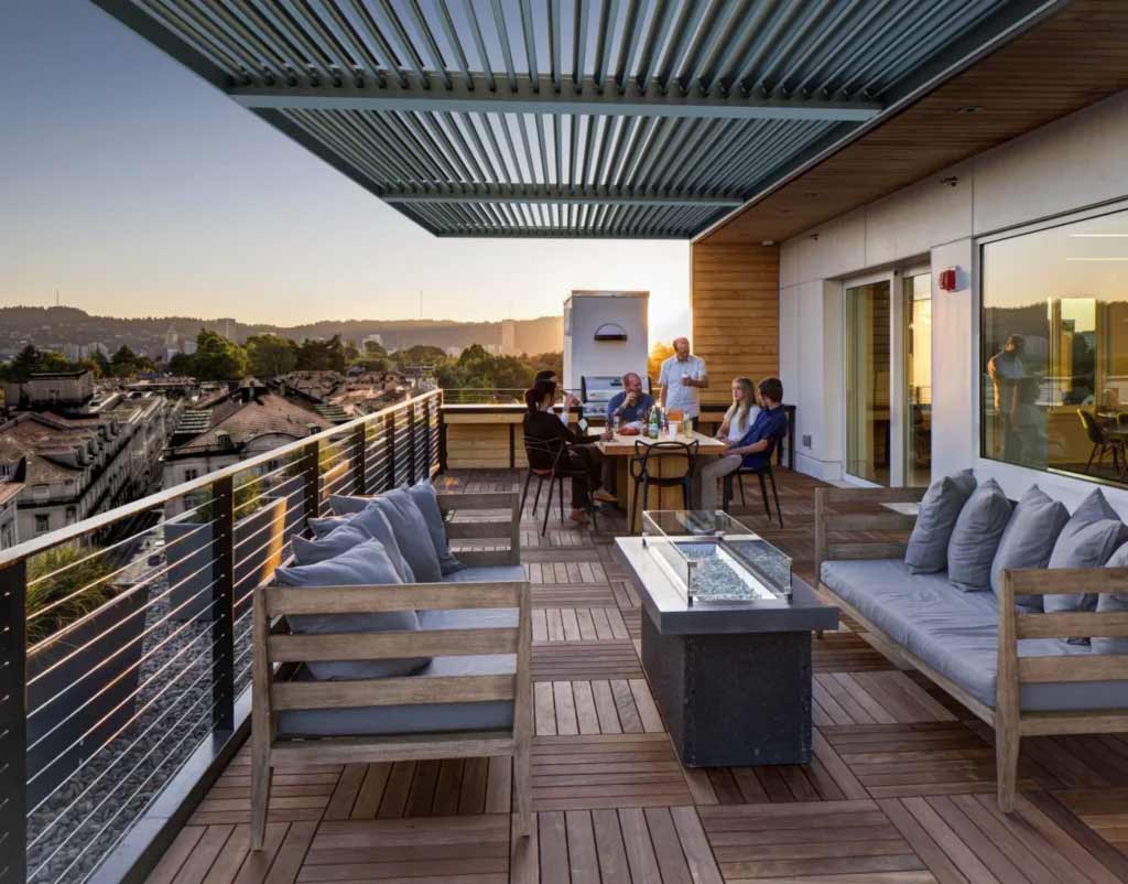 The aluminum pergola shades a dining table on a porch