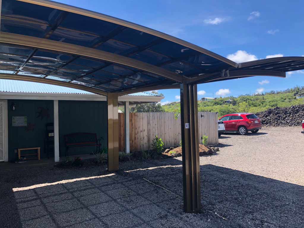 Double-car aluminum carport shades a parking area in a house